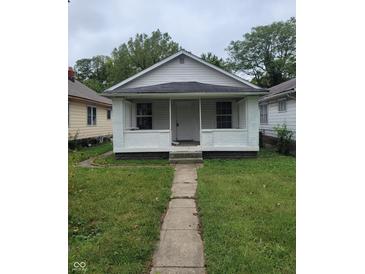 White brick home with a front porch and landscaped lawn at 1445 W 34Th St, Indianapolis, IN 46208