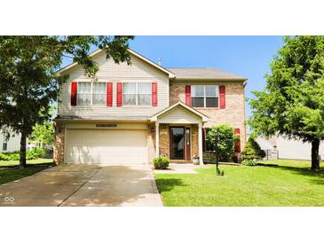 Charming two-story home with a well-maintained lawn, attached garage, and inviting front porch at 5340 Thompson Park Blvd, Indianapolis, IN 46237