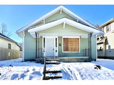 Green house with snow covered yard at 1218 N Ewing St, Indianapolis, IN 46201