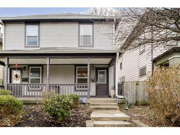 Two-story home with gray siding, front porch, and landscaping at 1421 E New York St, Indianapolis, IN 46201