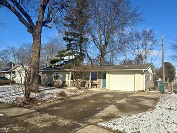 Ranch home with attached garage, landscaping, and a spacious driveway at 2108 W Sherman Dr, Muncie, IN 47304