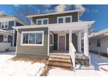 Charming two-story home featuring a covered front porch, gray siding, and a well-maintained lawn at 4014 N Capitol Ave, Indianapolis, IN 46208