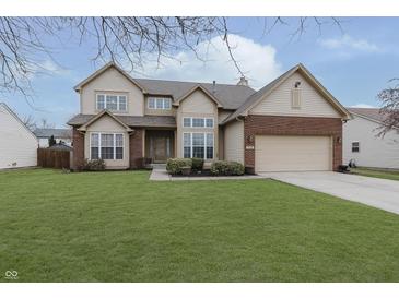 Two-story house with brick and siding, attached garage, and well-manicured lawn at 6023 Twyckenham Dr, Indianapolis, IN 46236