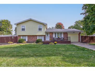 Ranch style home with brick and siding exterior, a deck, and a well-manicured lawn at 1801 Witt Rd, Lebanon, IN 46052