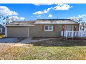 Green house with attached garage, white deck, and landscaping at 3415 Delmar Ave, Indianapolis, IN 46241