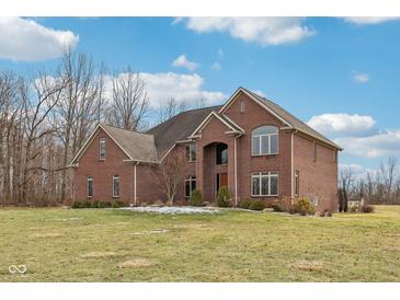 Elegant brick home featuring manicured landscaping and a spacious front lawn at 9263 Compton Farm Ln, Indianapolis, IN 46259