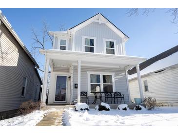 Two-story house with white siding, front porch, and snow-covered walkway at 1909 S Talbott St, Indianapolis, IN 46225