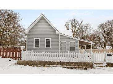 Gray sided house with white picket fence and snowy yard at 1430 St Paul St, Indianapolis, IN 46203