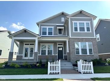 Two-story home with gray siding, brick accents, and a white picket fence at 20027 Old Dock Rd, Westfield, IN 46074