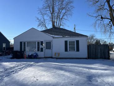 Ranch home with snow-covered yard, fenced-in area, and visible address number at 2301 S Vine St, Muncie, IN 47302