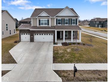 Inviting two-story home with a three-car garage, manicured lawn, and charming front porch at 4201 Risen Star Way, Bargersville, IN 46106