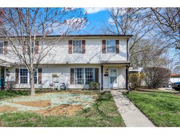 Charming two-story home with a walkway leading to the front door and green lawns on a sunny day at 4814 Oakwood Trl, Indianapolis, IN 46268