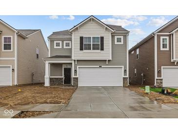 Charming two-story home features a two-car garage, covered entry, and stone accents at 5123 Rolling Meadow Blvd, Indianapolis, IN 46237