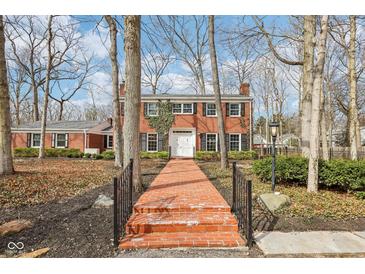 Stately two-story brick home with a red brick walkway and well-manicured landscaping at 7830 Ridgeland Dr, Indianapolis, IN 46250