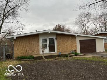 Ranch home with attached garage and brick facade at 1619 Elmhurst Dr, Indianapolis, IN 46219