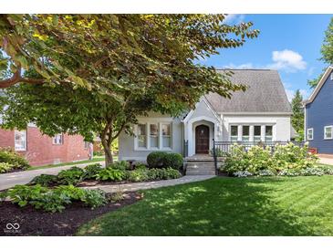 Charming gray brick home with manicured landscaping and a welcoming front porch at 5830 N New Jersey St, Indianapolis, IN 46220