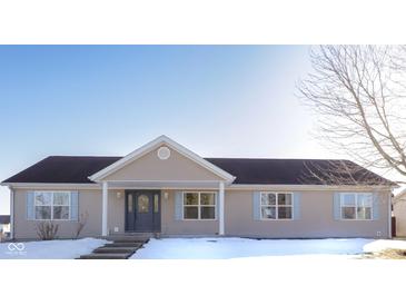 Tan one-story house with gray door, snow-covered lawn, and leafless tree at 1685 Juniper Dr, Columbus, IN 47201