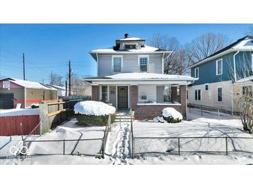 Two-story house with brick front and covered porch, snow-covered yard at 2957 Winthrop Ave, Indianapolis, IN 46205