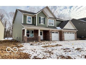 Two-story house with green siding, brick accents, and a three-car garage at 3647 Planck Cir, Danville, IN 46122