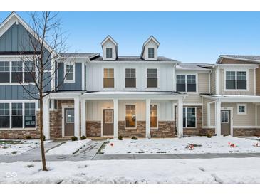 Two-story townhome with front porch, stone accents, and snow-covered landscaping at 3921 Wren Dr, Brownsburg, IN 46112