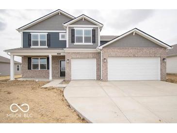 Charming two-story home featuring a brick facade, gray siding, attached two-car garage and well-manicured lawn at 6039 Granby Dr, Whitestown, IN 46075