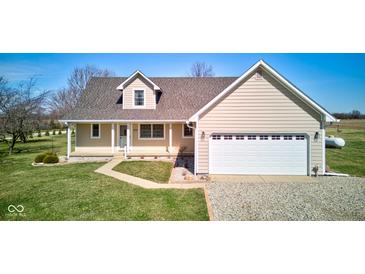 Inviting single-Gathering home featuring a manicured lawn, charming facade, and an attached two-car garage at 8116 E 900 N, Wilkinson, IN 46186