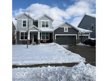 Two-story home with gray siding, snow-covered lawn, and attached garage at 15998 Bugle Ridge Dr, Noblesville, IN 46060