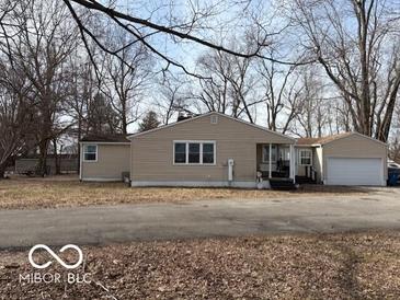 Beige ranch house with attached garage, situated on a tree-lined lot at 3970 N Bradford Rd, Martinsville, IN 46151