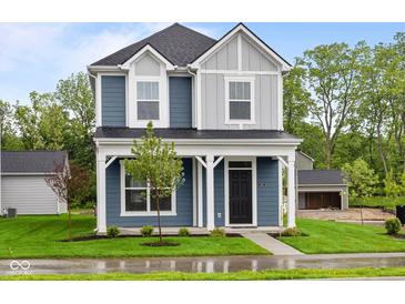 Charming two-story home with a covered front porch and well-manicured lawn at 1705 Real St, Indianapolis, IN 46240