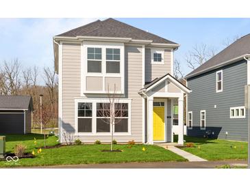 Charming two-story home with light gray siding, white trim, bright yellow door and manicured lawn at 1709 Real St, Indianapolis, IN 46240