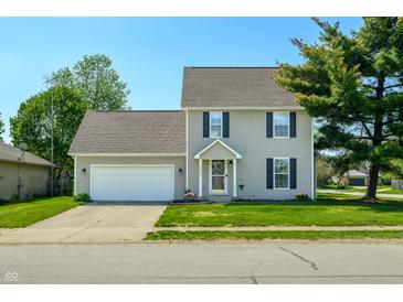 Charming two-story home with attached two car garage, a well-maintained lawn and colorful flowerbeds at 2062 Sumpter Trl, Columbus, IN 47203