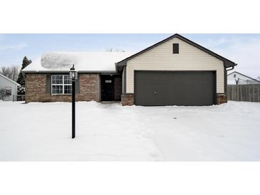 Brick ranch home with attached garage, freshly fallen snow on the ground at 3249 Cherry Lake Ln, Indianapolis, IN 46235