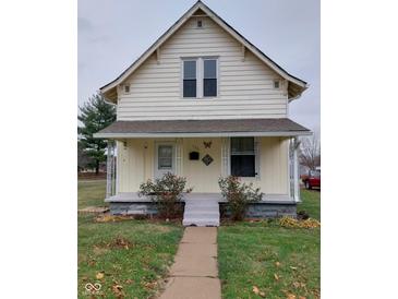 A charming yellow house with a front porch and yard at 325 S Market St, Thorntown, IN 46071