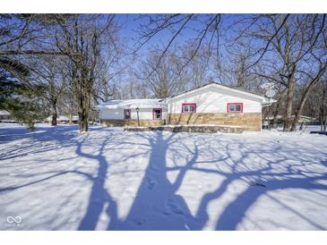 White house with stone accents, snow-covered yard, and tree shadows at 4201 Westbourne Dr, Indianapolis, IN 46205