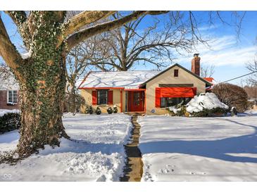 Snow-covered charming house with red awnings and stone pathway at 6072 Meridian St W Dr, Indianapolis, IN 46208