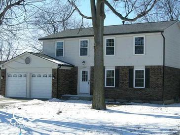 Two-story house with a brick and siding exterior, two-car garage, and mature trees at 6704 Zionsville Rd, Indianapolis, IN 46268