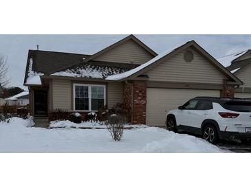 Tan house with a brown roof, brick accents, and a two-car garage; snow on the ground at 1294 Lexington Trl, Greenfield, IN 46140