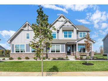 Beautiful two-story home with a manicured lawn and a combination of brick and siding exterior at 19452 Lewis Cir, Westfield, IN 46074