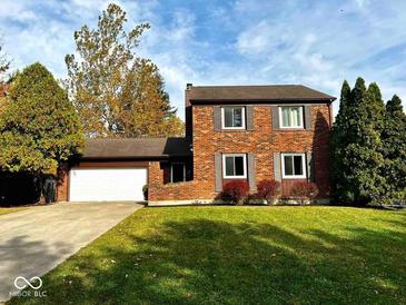 Charming two-story brick home featuring well-manicured lawn and attached two-car garage at 30 Village Ct, Zionsville, IN 46077