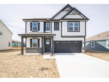 Two-story home with a black-and-white color scheme, front porch, and a two-car garage at 8798 Walker St, Fortville, IN 46040