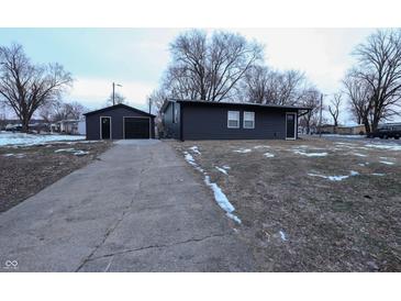 Newly renovated home with dark siding, detached garage, and a paved driveway at 1384 Cross St, Martinsville, IN 46151