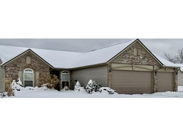 Brick house with 2-car garage, snow covered landscaping at 2423 Canvasback Dr, Indianapolis, IN 46234