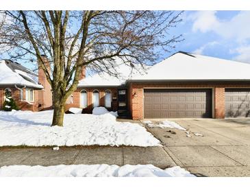 Brick ranch home with attached garage, snow covered landscaping, and a tree in the front yard at 243 Andrews Blvd, Plainfield, IN 46168