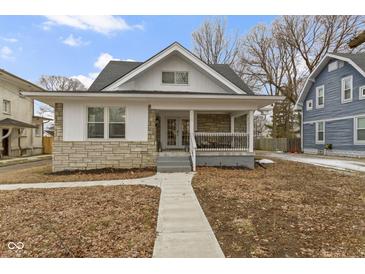 Charming home showcasing stone accents, a covered porch, and a welcoming walkway at 3838 Winthrop Ave, Indianapolis, IN 46205