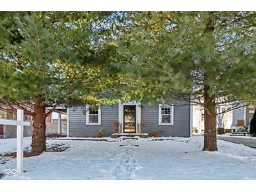 Gray house with white trim, snow-covered yard, and pine trees at 5108 N College Ave, Indianapolis, IN 46205