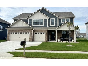 Charming two-story home featuring a manicured lawn, brick accents, and a welcoming front porch at 5442 W Turnbuckle Pl, McCordsville, IN 46055