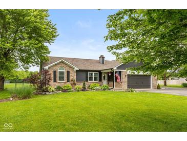 Charming exterior view of home with brick accents, manicured lawn, and an attached two-car garage at 7775 N Kitchen Rd, Mooresville, IN 46158