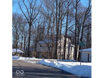 Two-story house with beige siding, stone accents, and snow-covered landscaping at 941 Sleepy Hollow Pl, Greenwood, IN 46142