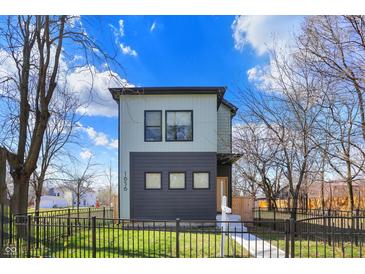 Charming two-story home with modern design elements and a well-manicured front yard and black metal fence at 1656 Roosevelt Ave, Indianapolis, IN 46218