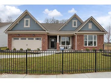 Charming home with red brick, blue accents, and a well-manicured lawn behind a decorative black metal fence at 19341 Sumrall Pl, Westfield, IN 46074